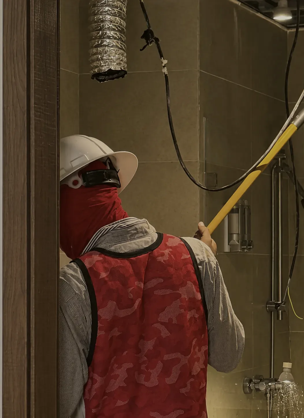 Contratista trabajando en la obra de un baño bajo la dirección del estudio